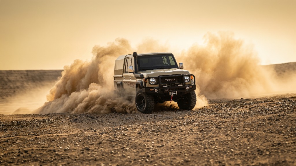 Black Chevrolet Tahoe on a mountain road with snow-covered peaks